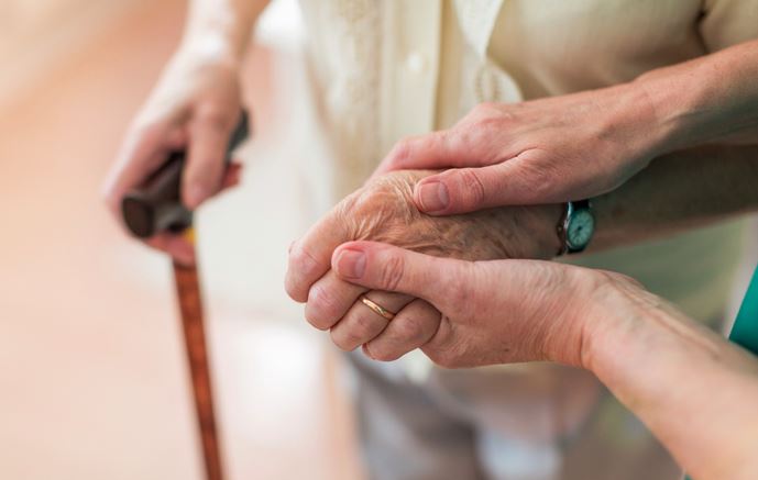 Dando la mano a una persona mayor