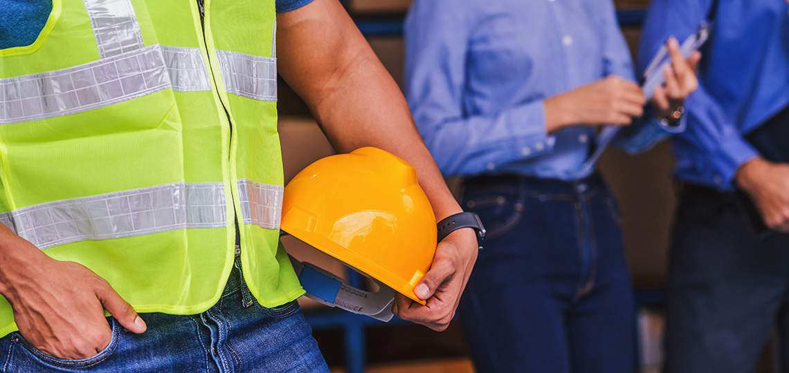 Obrero sujetando un casco amarillo