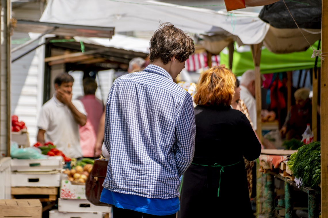 joven caminando entre la multitud en el mercado de la ciudad