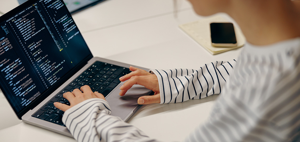 Persona trabajadora programando en ordenador